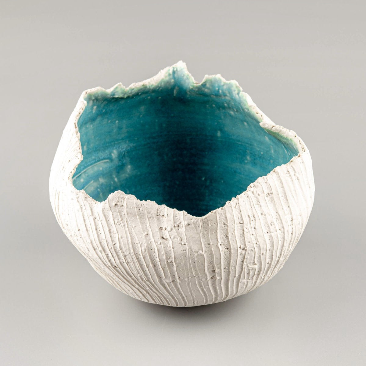 Artisan-crafted pottery vase with textured shell-like surface and deep turquoise finish for collectible pottery.