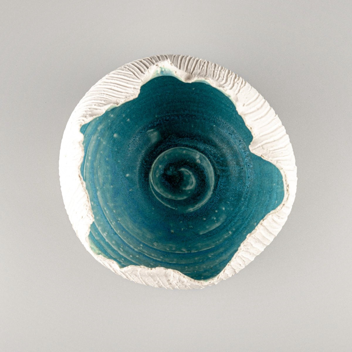 Limited-edition stoneware vase featuring an organic rim and ocean-inspired turquoise glaze, perfect for boutique hotels.