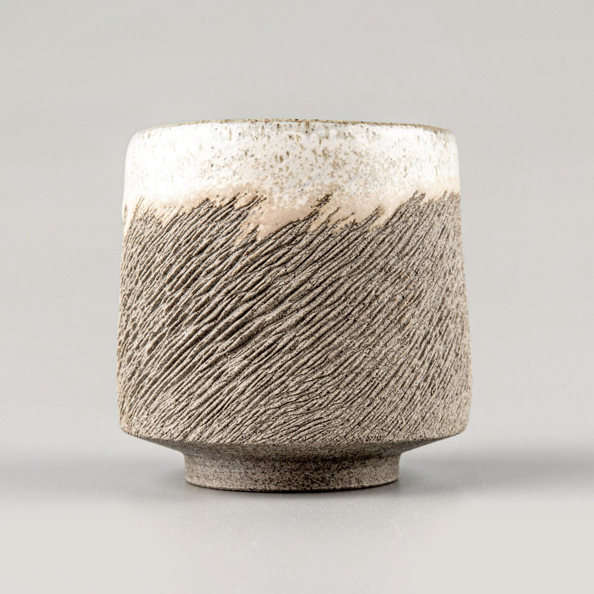 Handcrafted stoneware coffee cups with carved texture and semi-gloss white glaze, ideal for fine restaurants and hotel use.