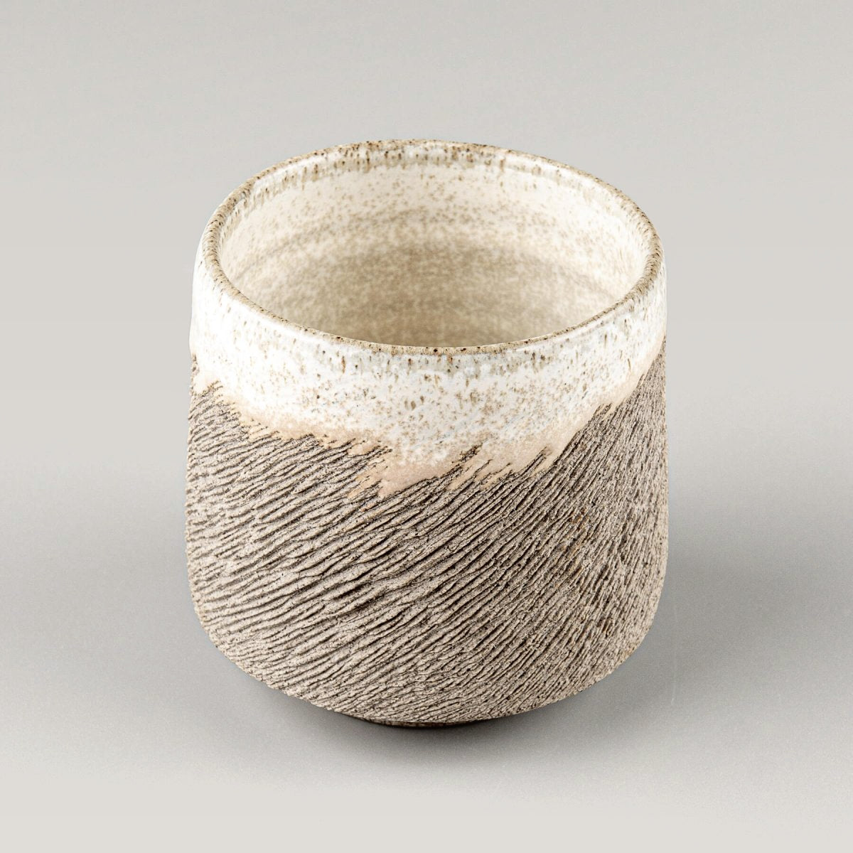 Top view of handmade stoneware coffee cup with white glaze interior, for kitchenware, tableware, and culinary presentation.