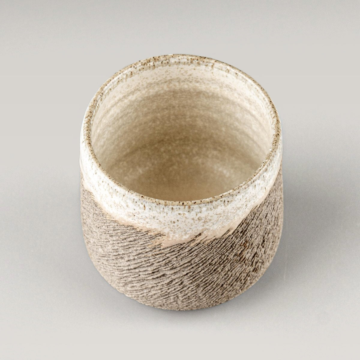 Elegant stoneware coffee cup with carved exterior detail and artistic glaze, suitable for fine dining restaurants and hotels.