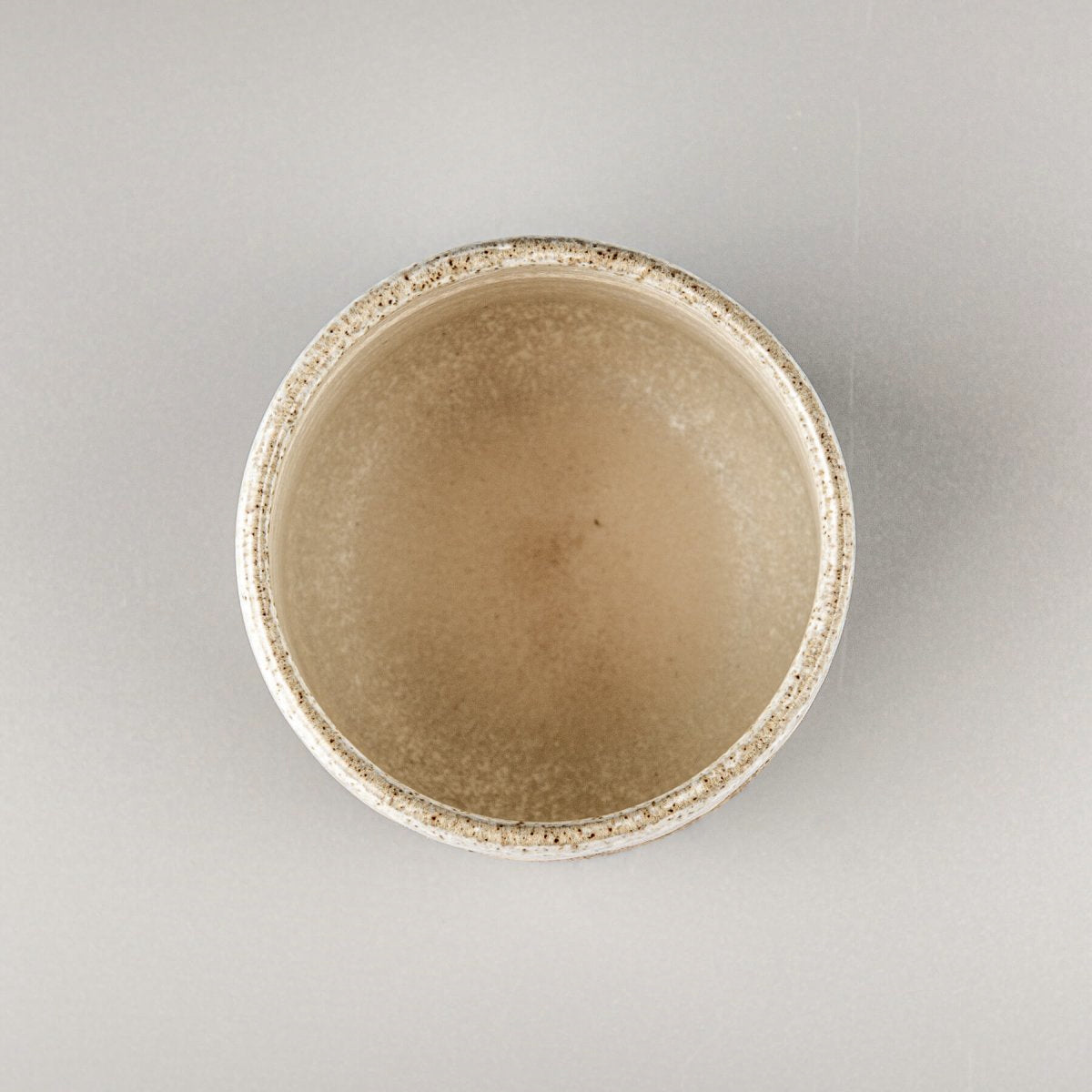Top view of handmade stoneware coffee cup with smooth glazed interior, perfect for kitchenware and culinary presentation.