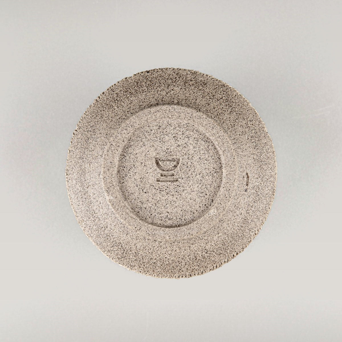 Bottom view of handcrafted stoneware coffee cup showing artist’s wheel-thrown finish.