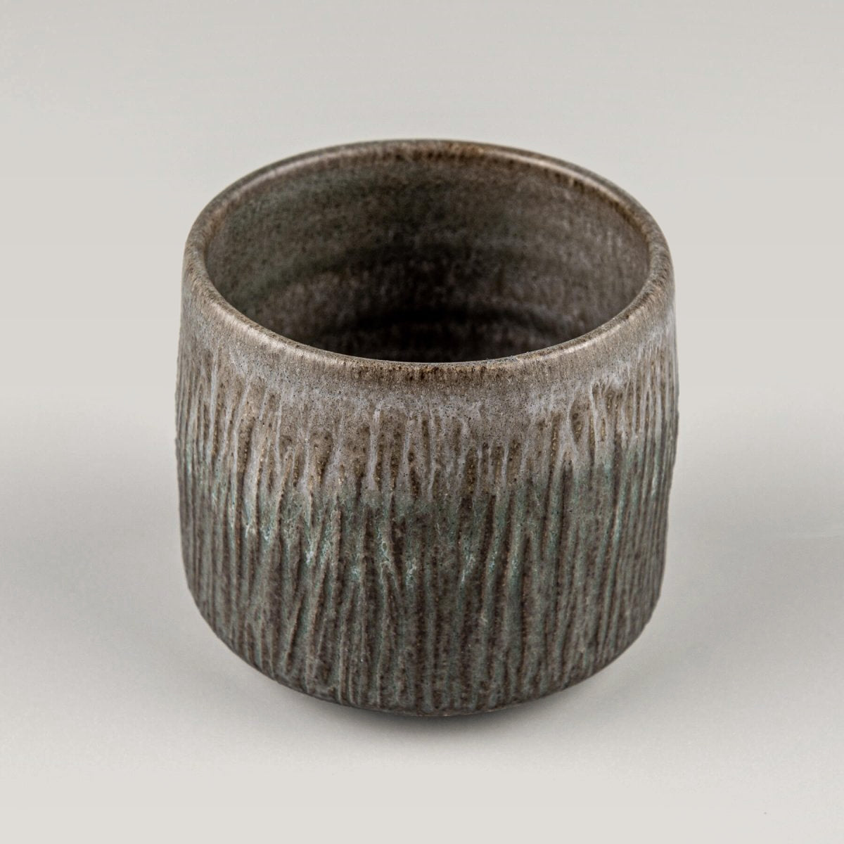Unique handmade stoneware cup with raised base and modern design, collectible pottery for interior design.