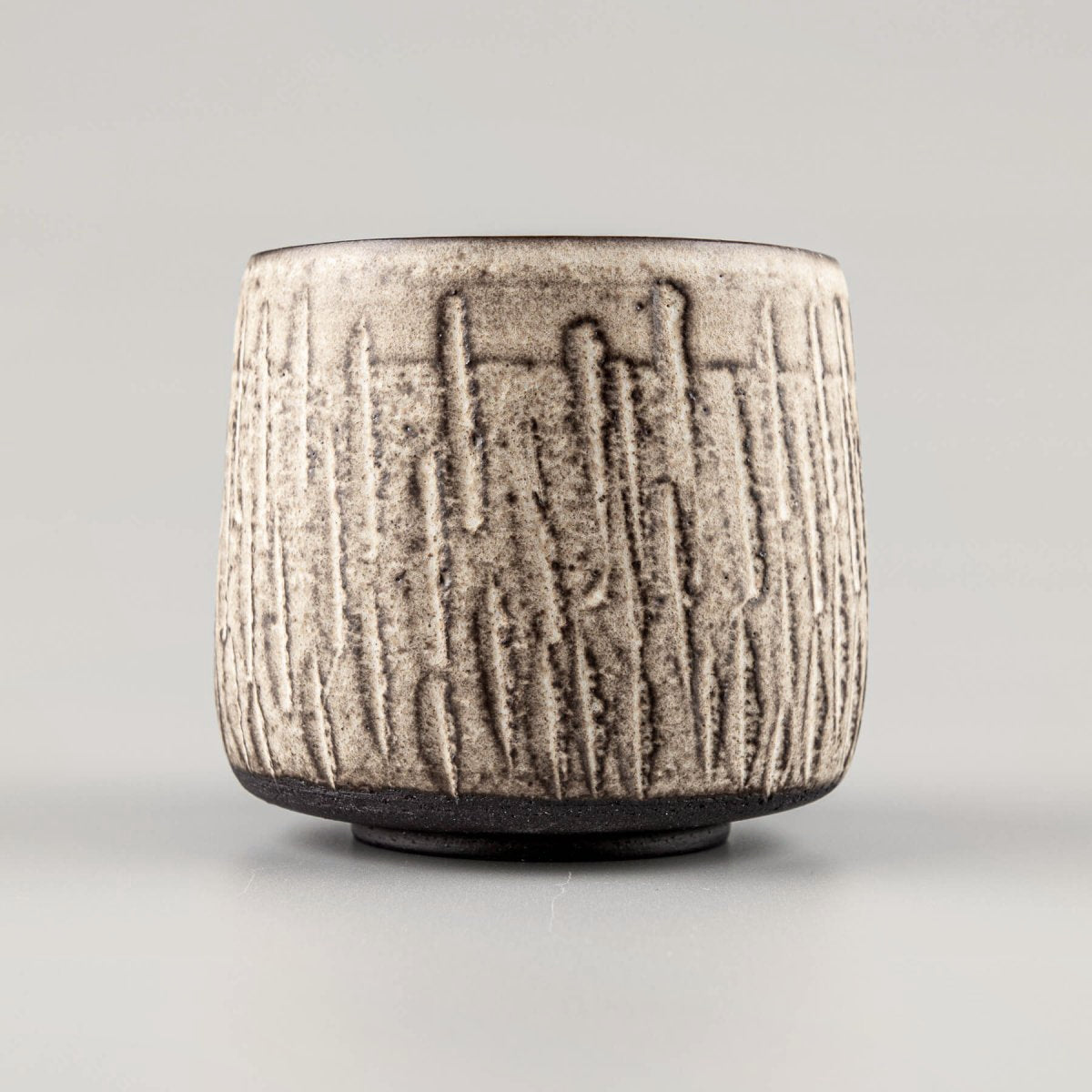Handcrafted ceramic mugs with carved stoneware texture and matte white glaze, ideal for home and restaurant tableware.