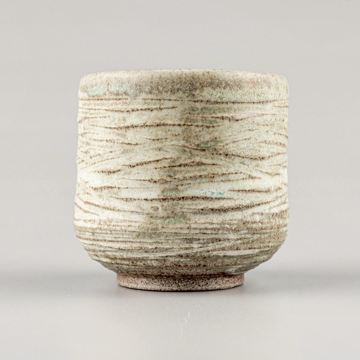 Handmade mugs with stoneware clay and carved texture for home and restaurant tableware.