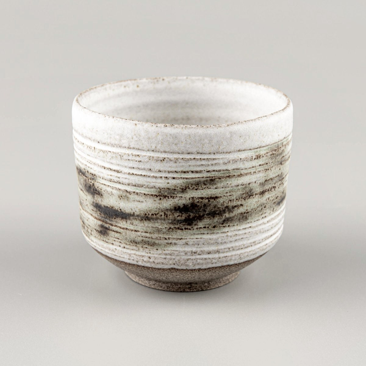 Artisan pottery mugs with rustic raw clay base and matte glaze finish.