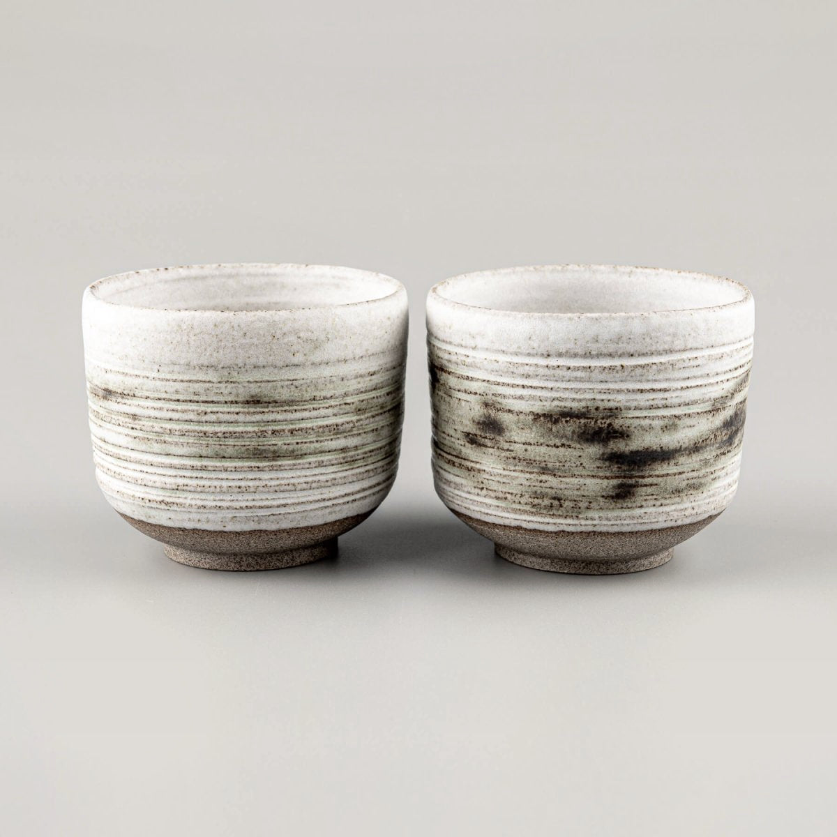 Stoneware mugs with textured exterior, perfect for coffee, tea, or fine dining presentation.