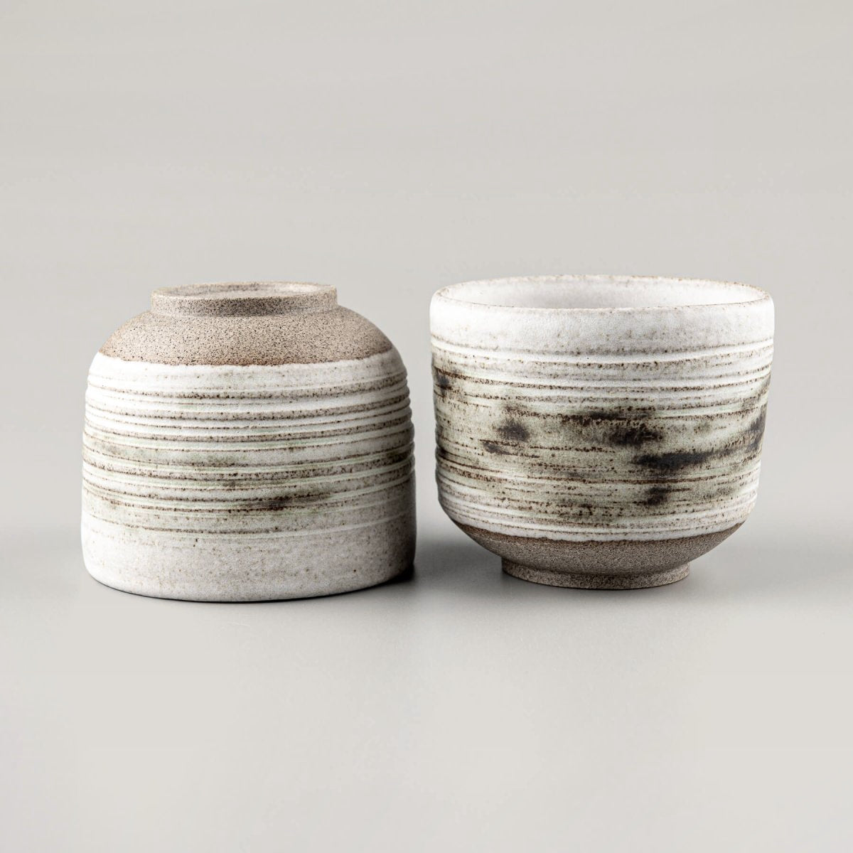 Unique stoneware mugs showcasing modern craftsmanship and carved detailing.
