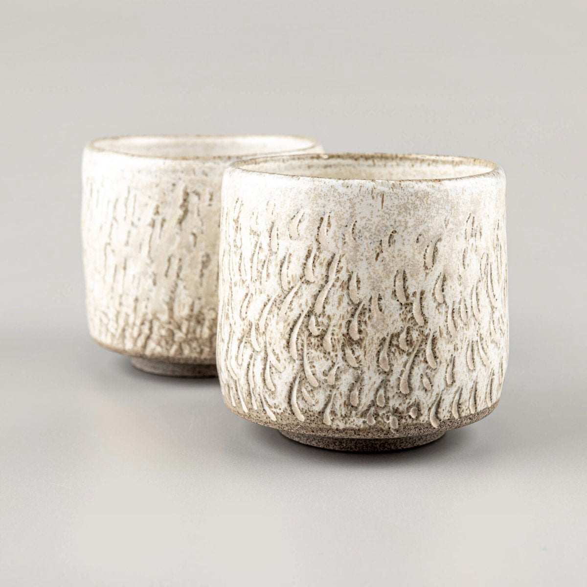 Handcrafted ceramic espresso cups set with carved texture and matte glaze for modern kitchenware.