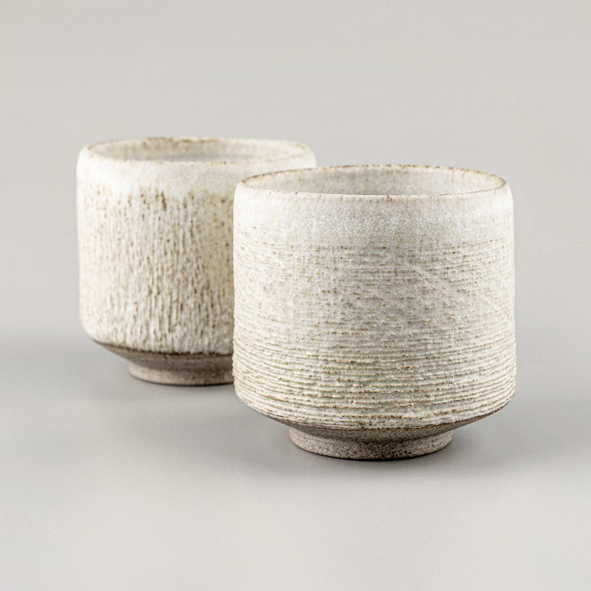 Handcrafted pottery mugs with white matte glaze, ideal for coffee, tea, and collectible kitchenware.