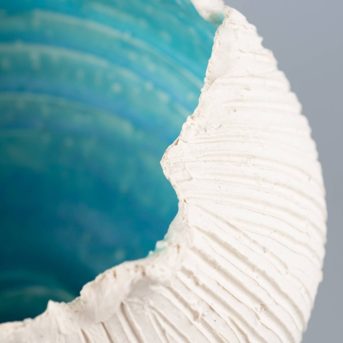 Handmade stoneware vase, featuring a close-up view of a textured white surface and turquoise glaze, ideal for luxury decor.