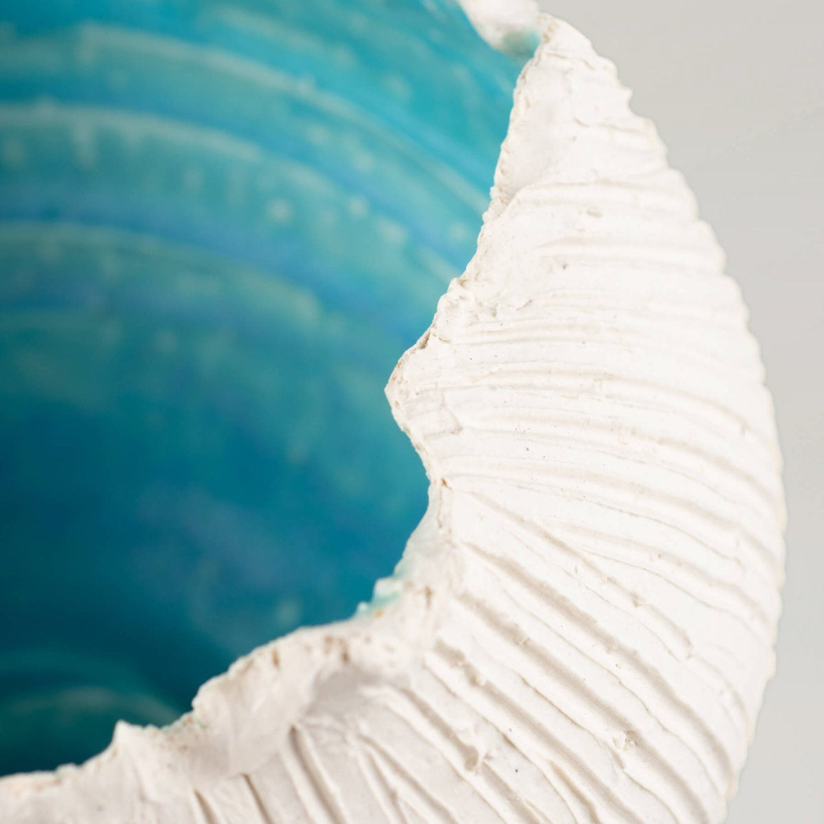 Handmade stoneware vase, featuring a close-up view of a textured white surface and turquoise glaze, ideal for luxury decor.