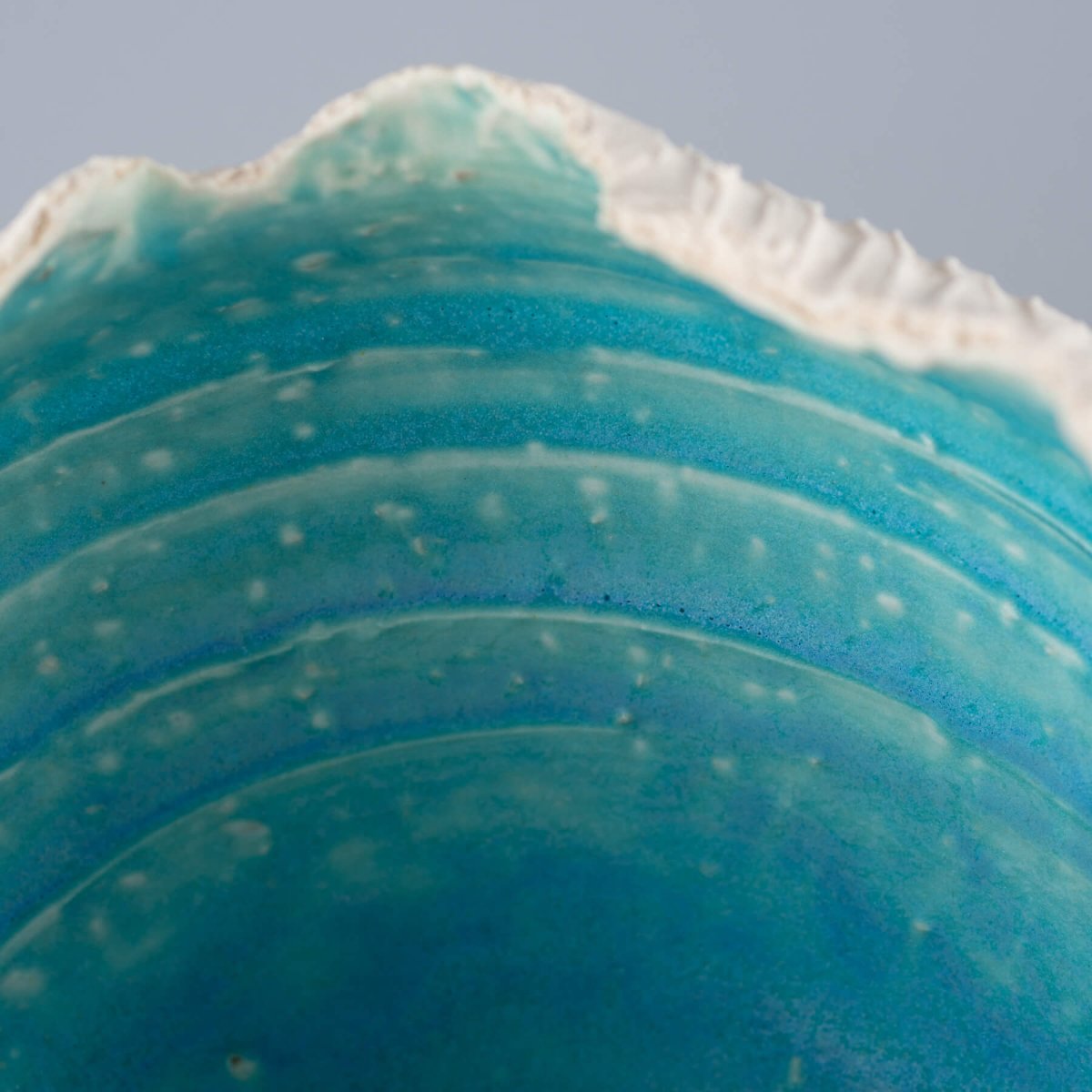 Close-up of handcrafted stoneware vase interior with deep turquoise glaze, ideal for collectible pottery and home decor.