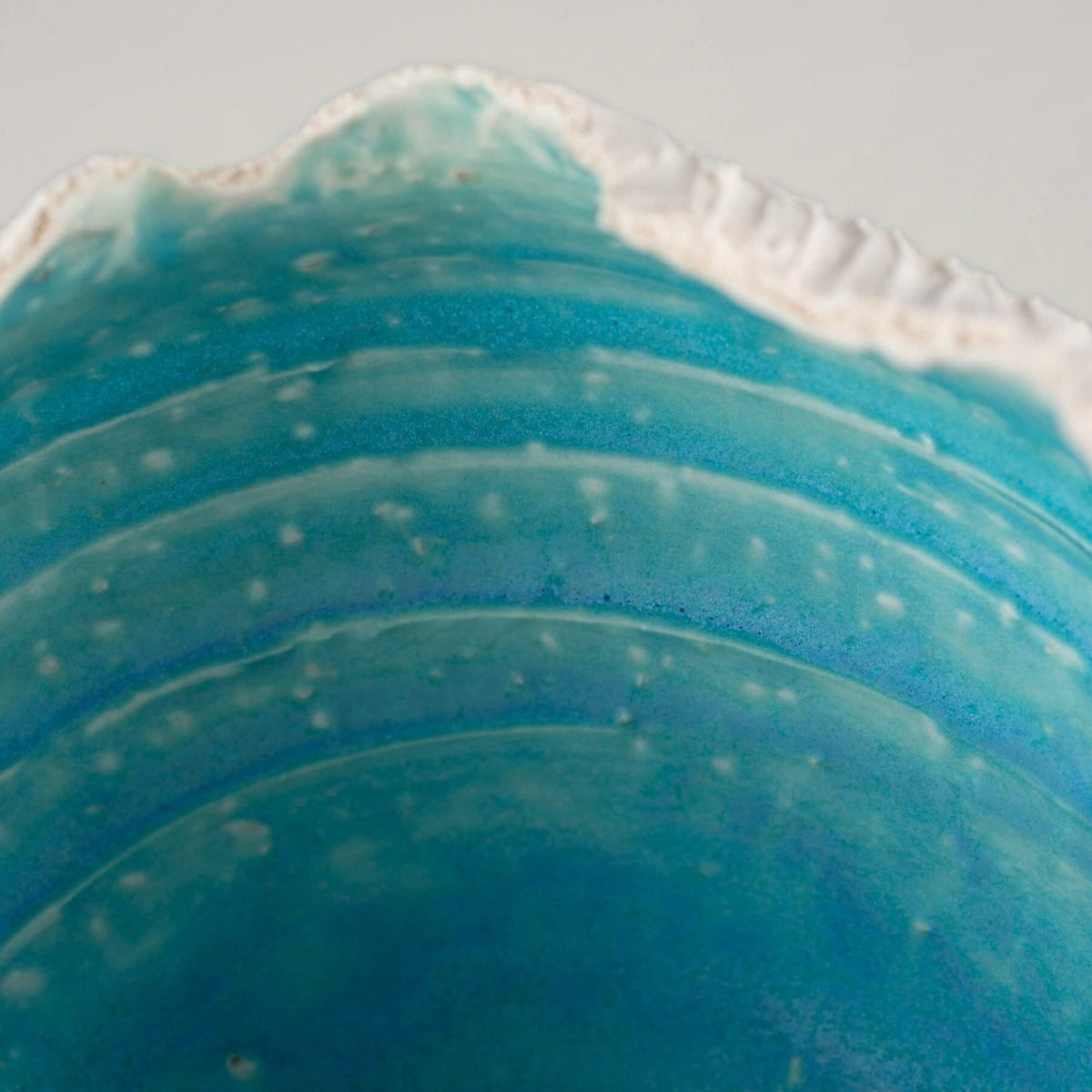 Close-up of handcrafted stoneware vase interior with deep turquoise glaze, ideal for collectible pottery and home decor.
