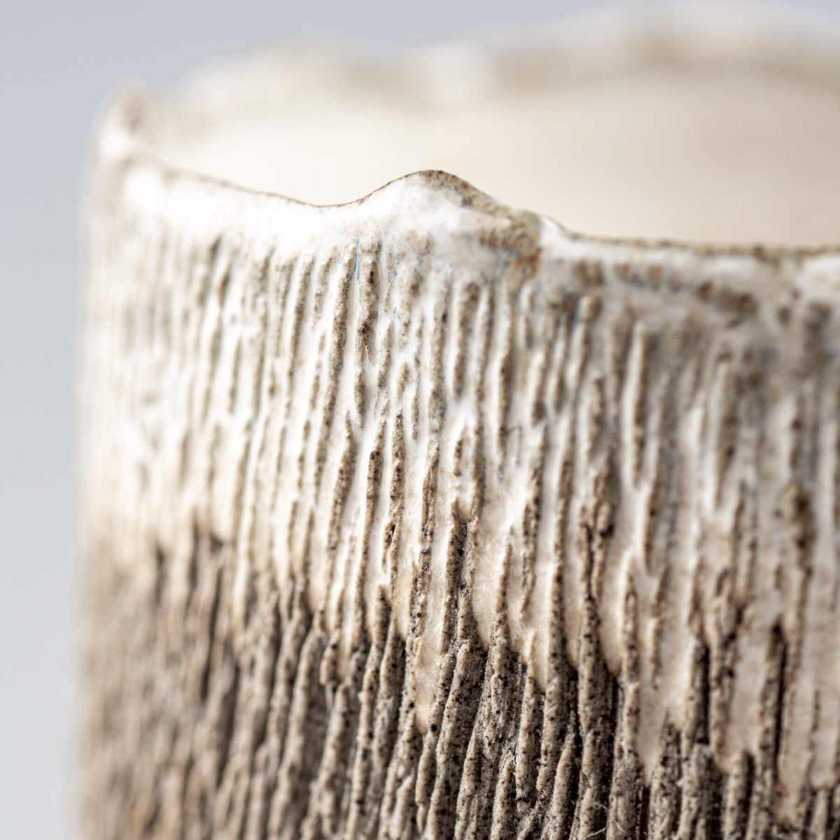 Textured handmade coffee cup with glazed interior, perfect for culinary presentation.