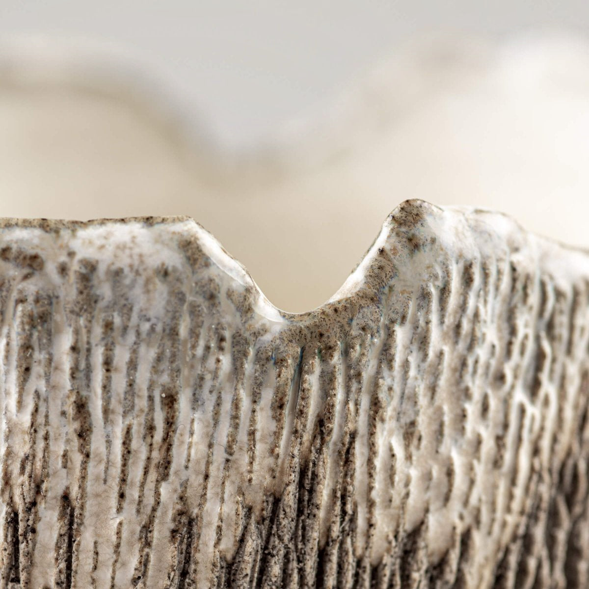 Close-up of carved vertical texture on handmade stoneware coffee cup for home and restaurants.