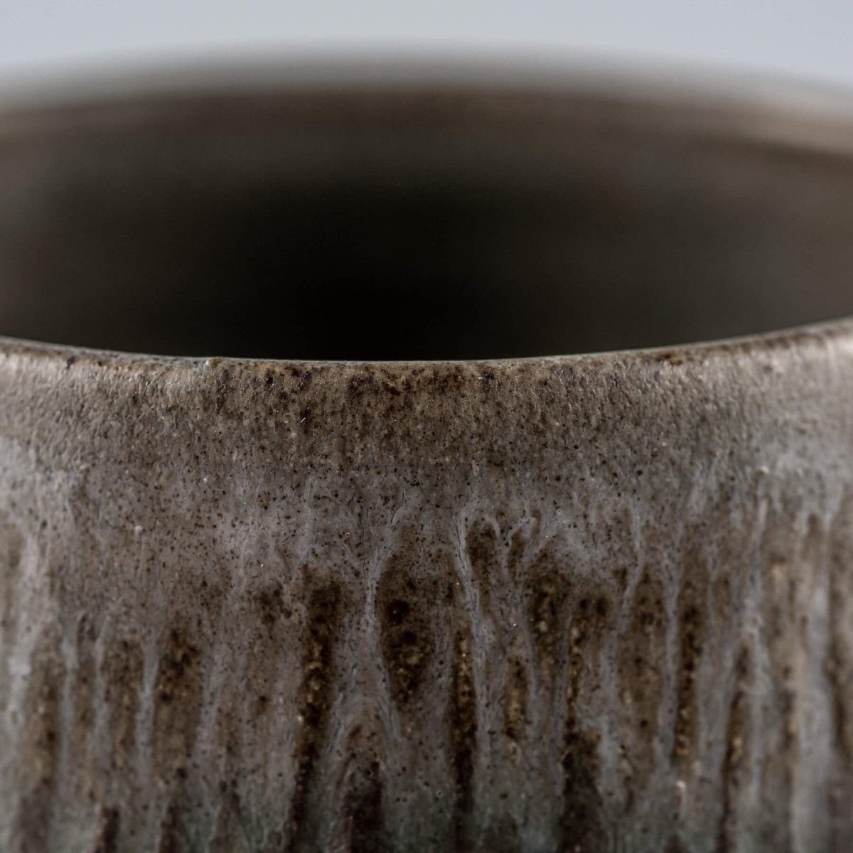 Sleek ceramic coffee cups with elevated base and textured surface, designed for culinary presentation.