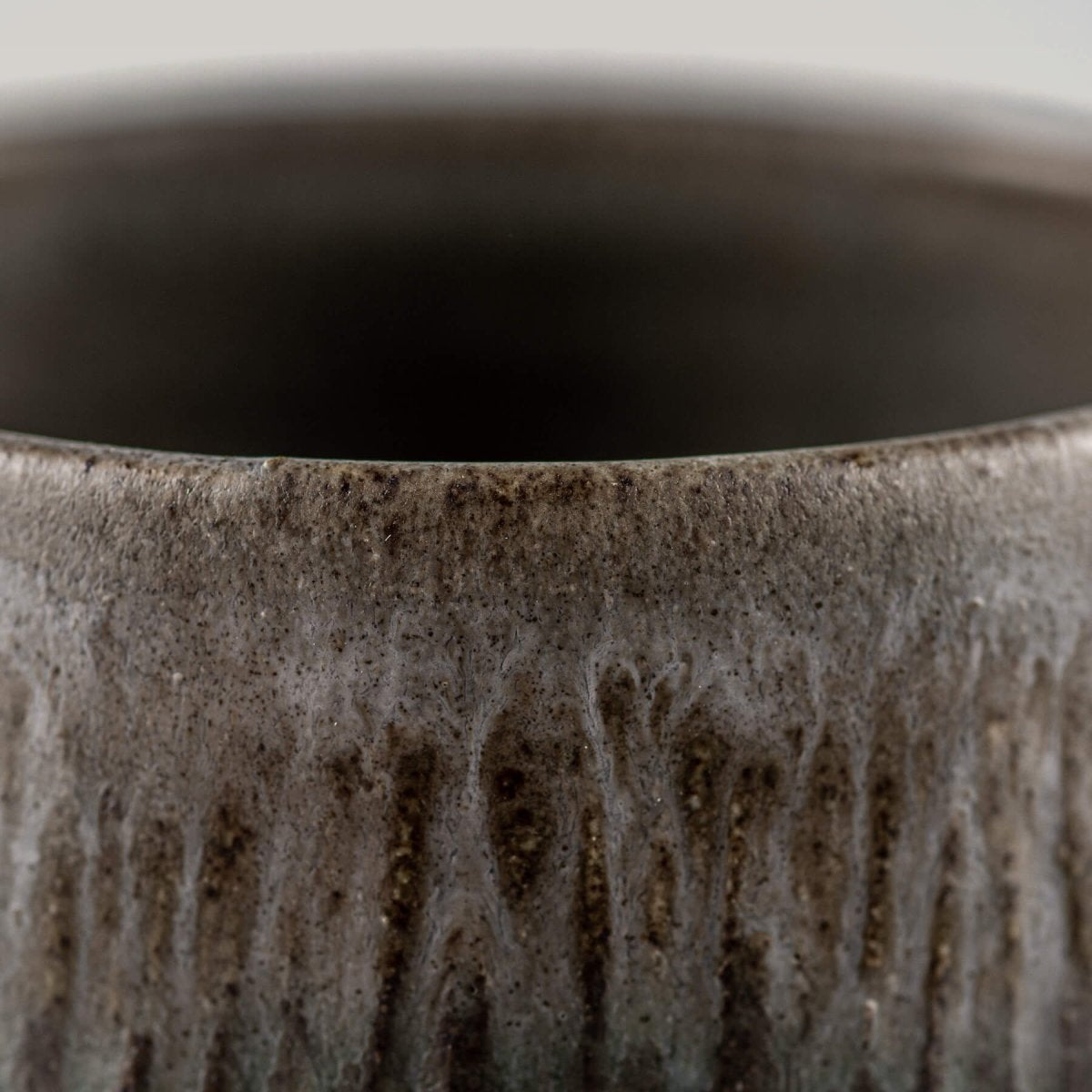 Sleek ceramic coffee cups with elevated base and textured surface, designed for culinary presentation.