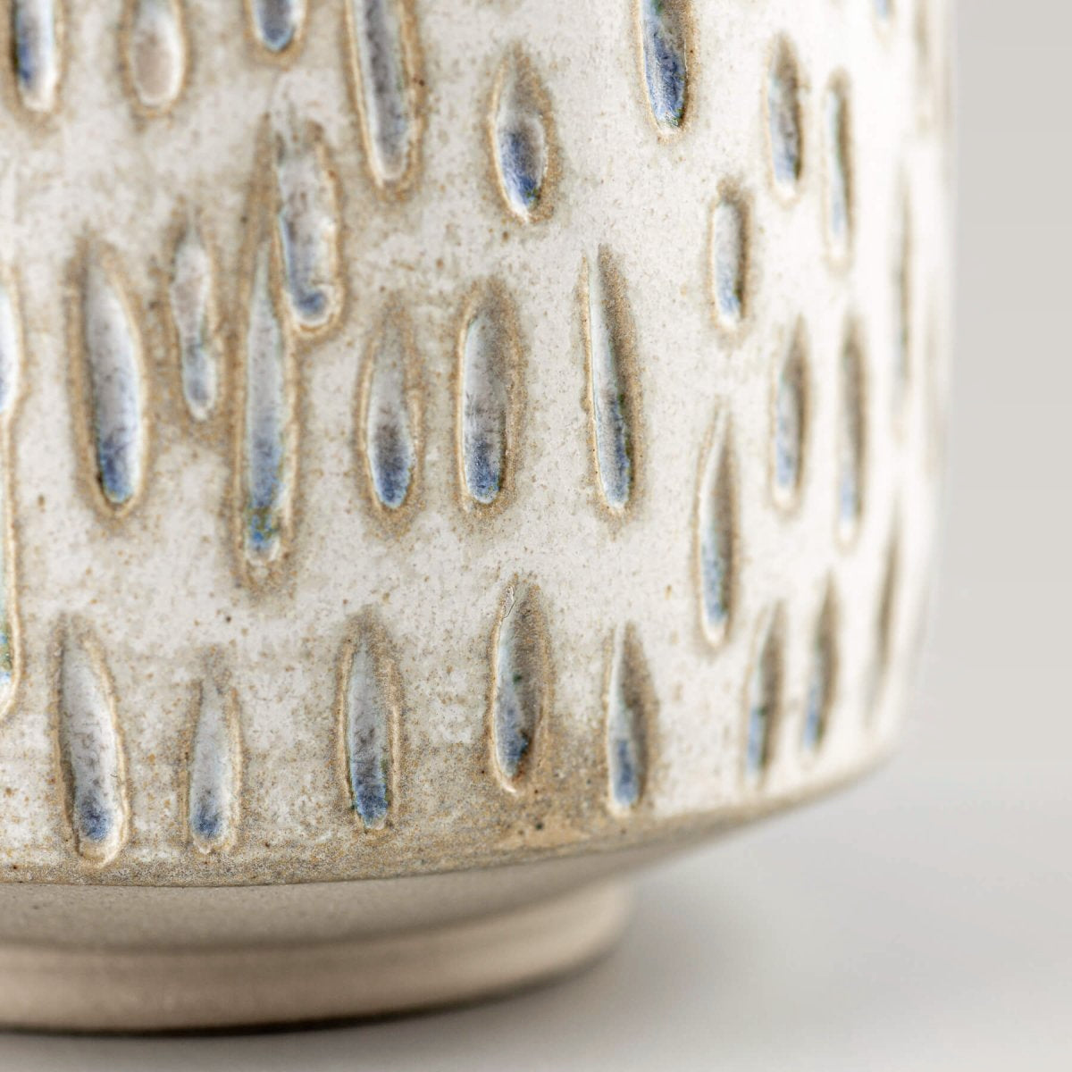Handcrafted ceramic espresso cup with droplet carvings, highlighting artisan texture for home and fine dining.