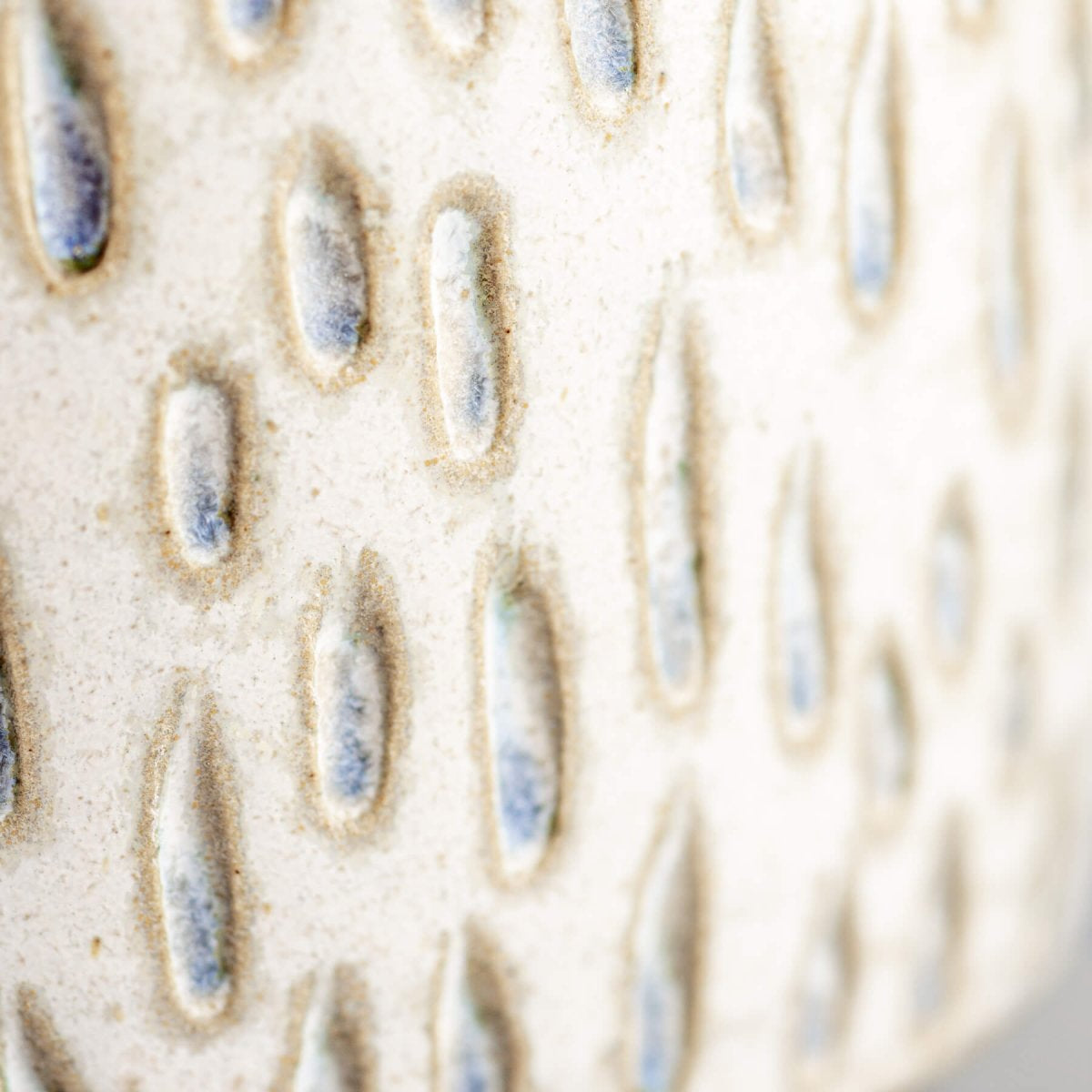 Detail of carved ceramic espresso cup with handmade droplet pattern, perfect for boutique hotel tableware.