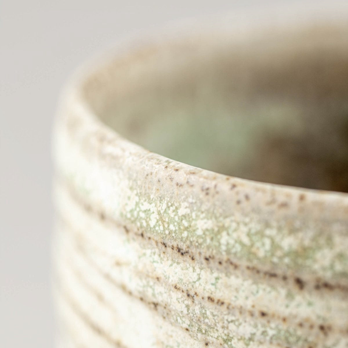 Unique handmade mug with subtle green glaze, suitable for home and culinary presentation.