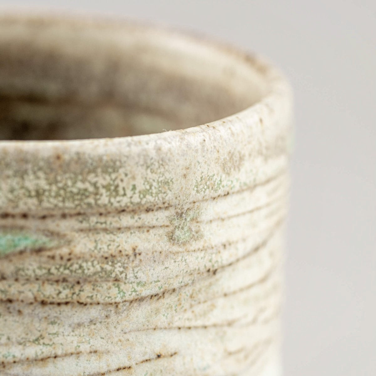 Ceramic handmade mug with rustic carved design, ideal for collectible pottery lovers.