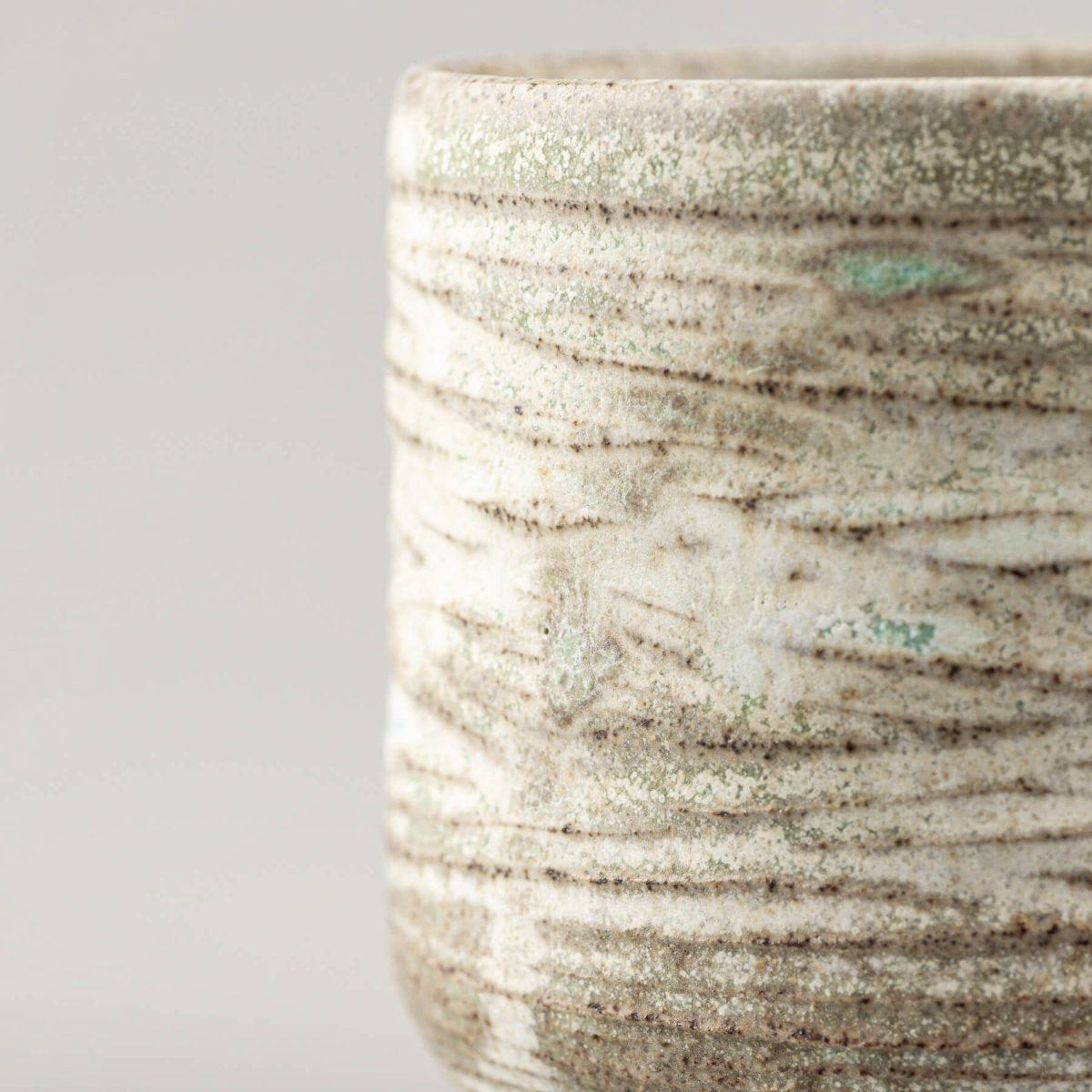 Stoneware handmade mug with artistic surface, blending modern kitchenware and handmade decor.