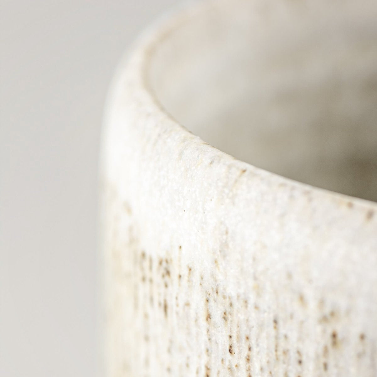 Handcrafted ceramic mug rim with matte glaze, showcasing artisanal pottery design.