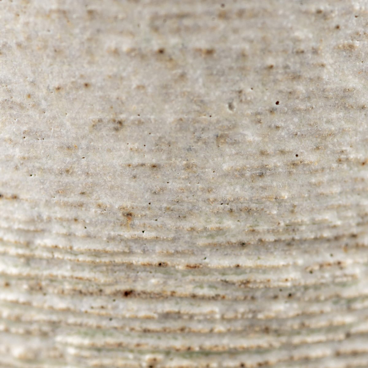 Textured stoneware surface detail of pottery mug, ideal for collectible kitchenware and handmade decor.