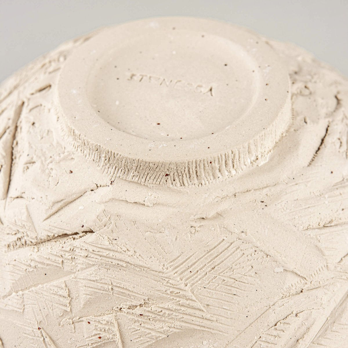 Bottom side view showing foot ring and unglazed ceramic texture on handcrafted bowl.