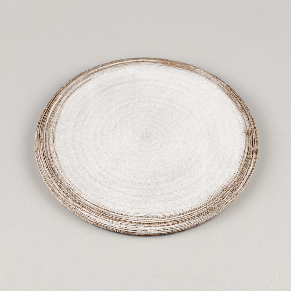 Top view of premium flat ceramic plate with hand-carved edges for culinary presentation.