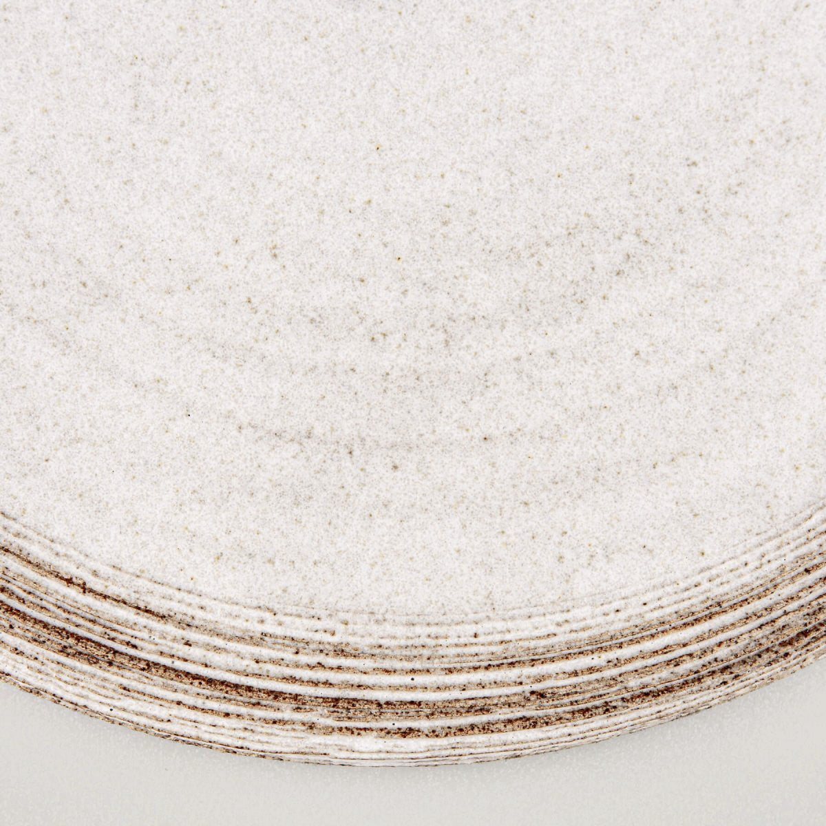 Close-up of matte white glaze contrasting with natural dark stoneware.