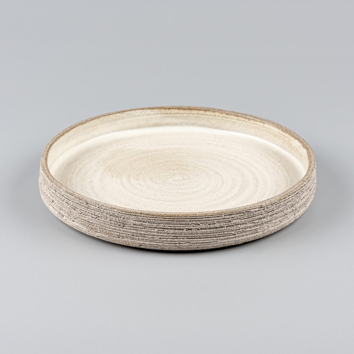 Luxury dinner plate with straight sides, flat base, and artisanal carved design.