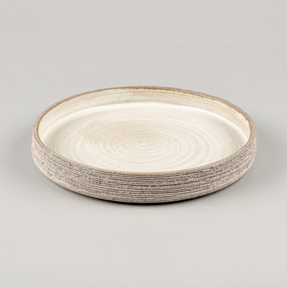 Luxury dinner plate with straight sides, flat base, and artisanal carved design.