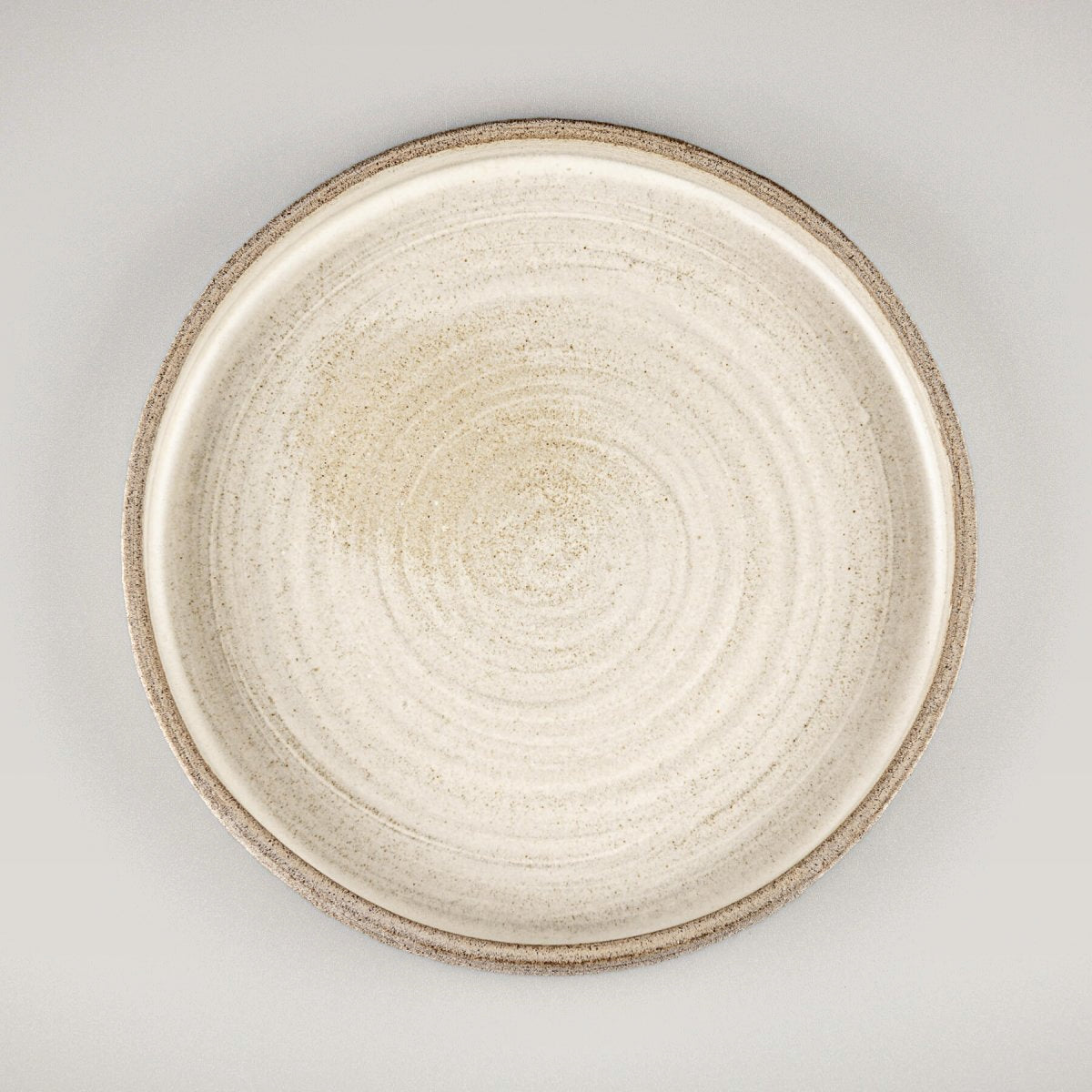 Elegant stoneware dinner plate with matte white glaze and hand-carved textured edges.
