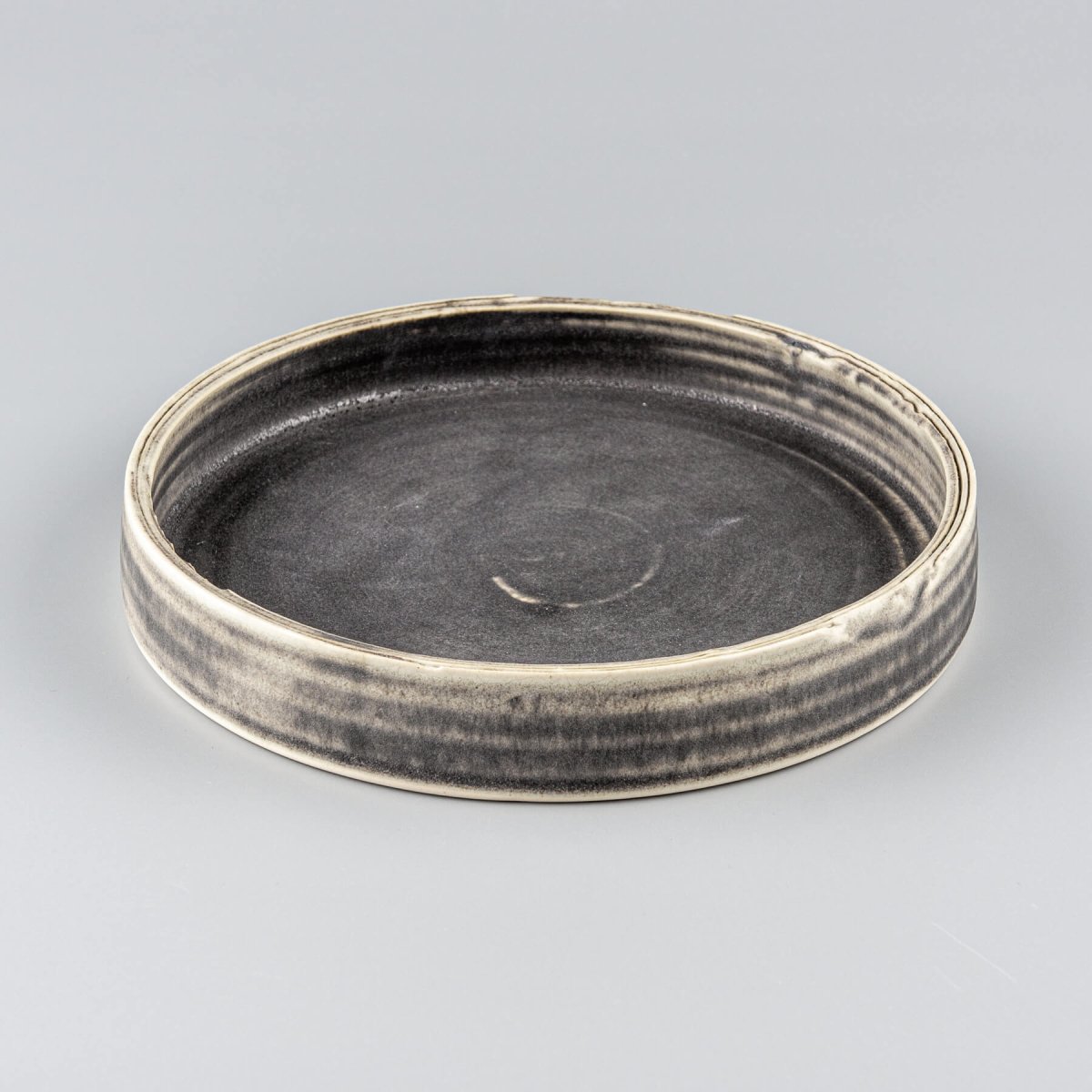 Artisanal stoneware plate with flat base and refined design, ideal for luxury restaurants and boutique hotels.