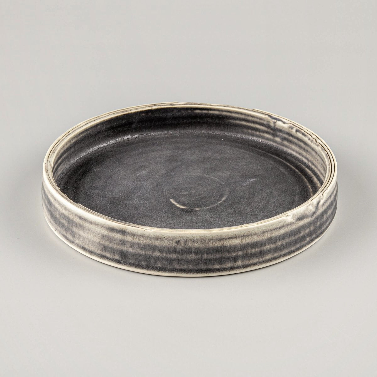 Artisanal stoneware plate with flat base and refined design, ideal for luxury restaurants and boutique hotels.
