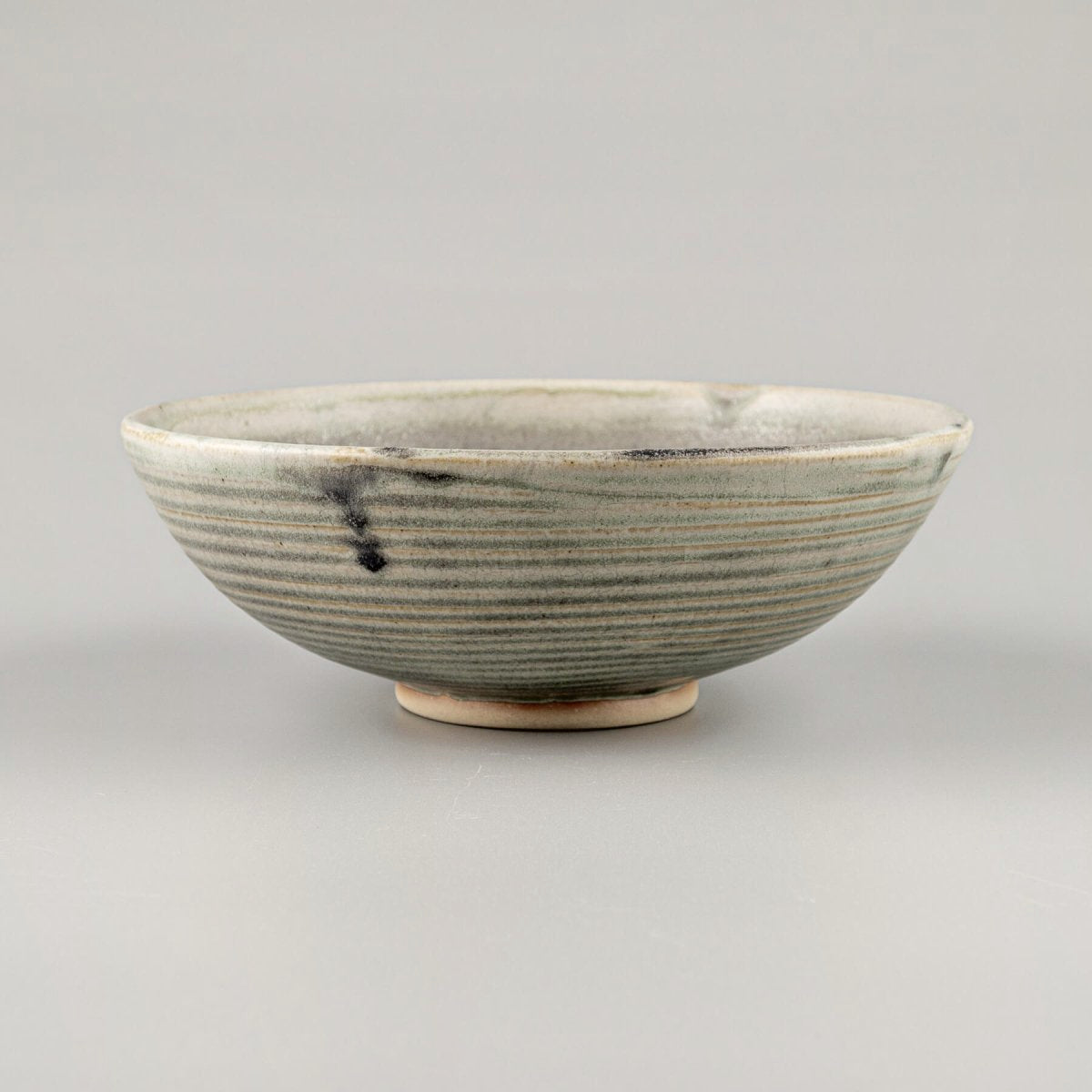 Artisan ceramic bowl with olive matte glaze and hand-carved stoneware texture for kitchenware and collectible pottery.