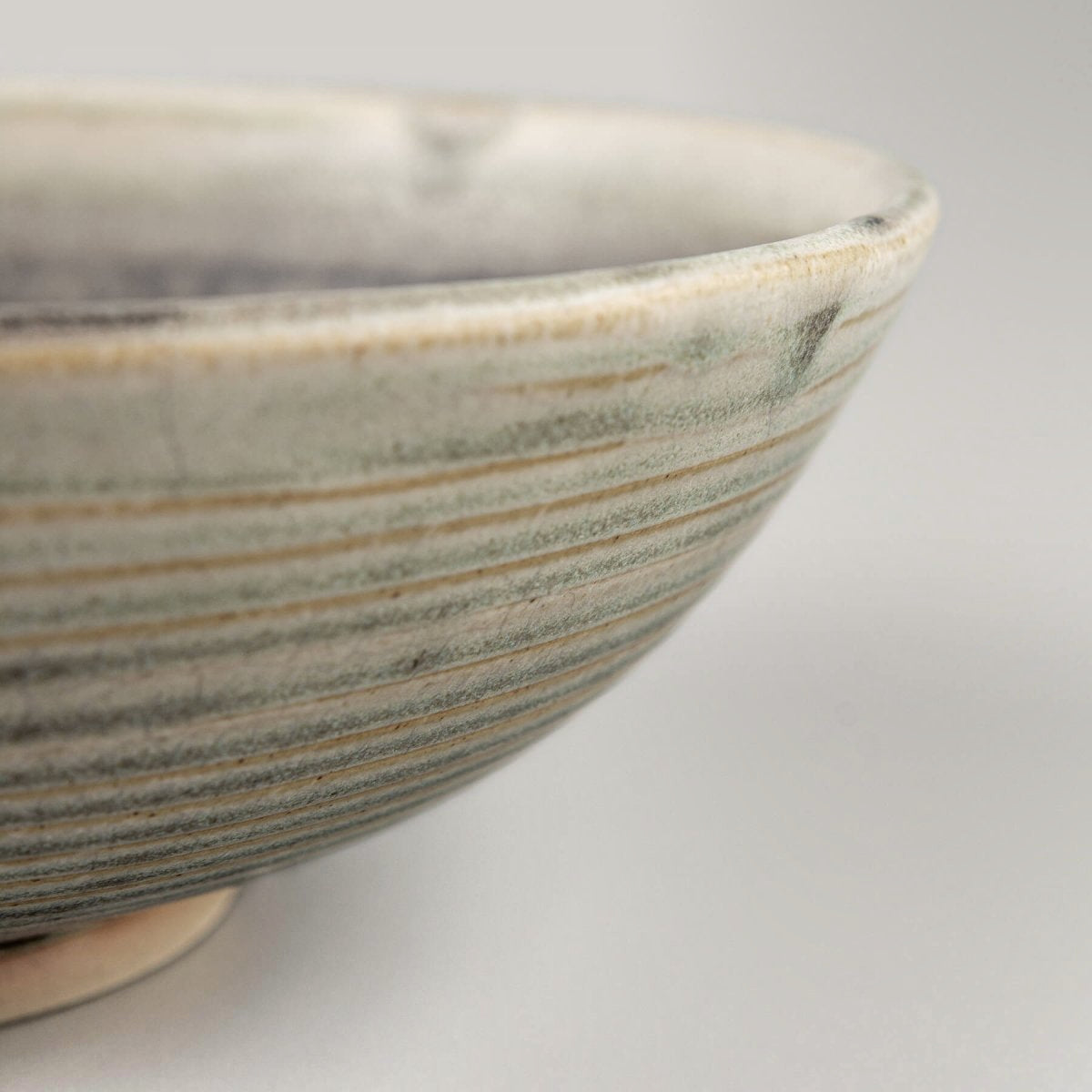 Decorative ceramic bowl with artisan craftsmanship and minimal glaze for rustic and modern table arrangements.