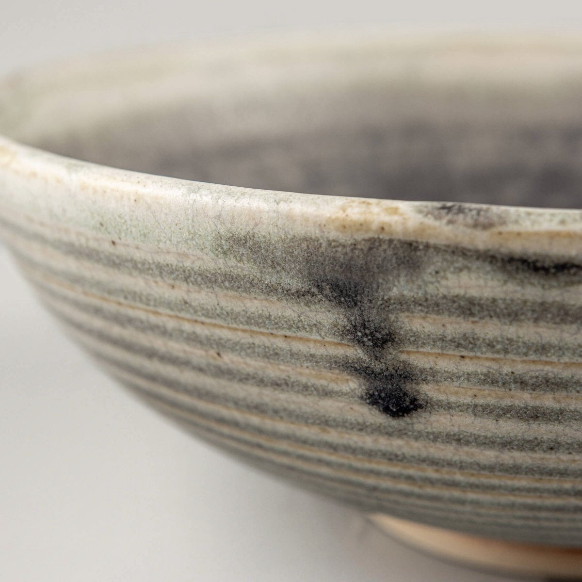 Handmade ceramic bowl with unique beveled form and contrast of smooth glaze and natural clay body.