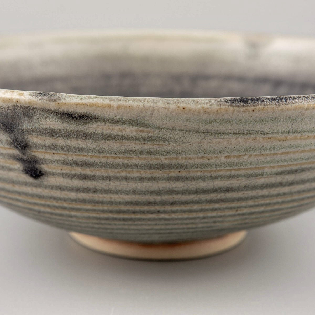 Collectible pottery bowl with olive green interior glaze and sculptural form, designed for elevated dining experiences.