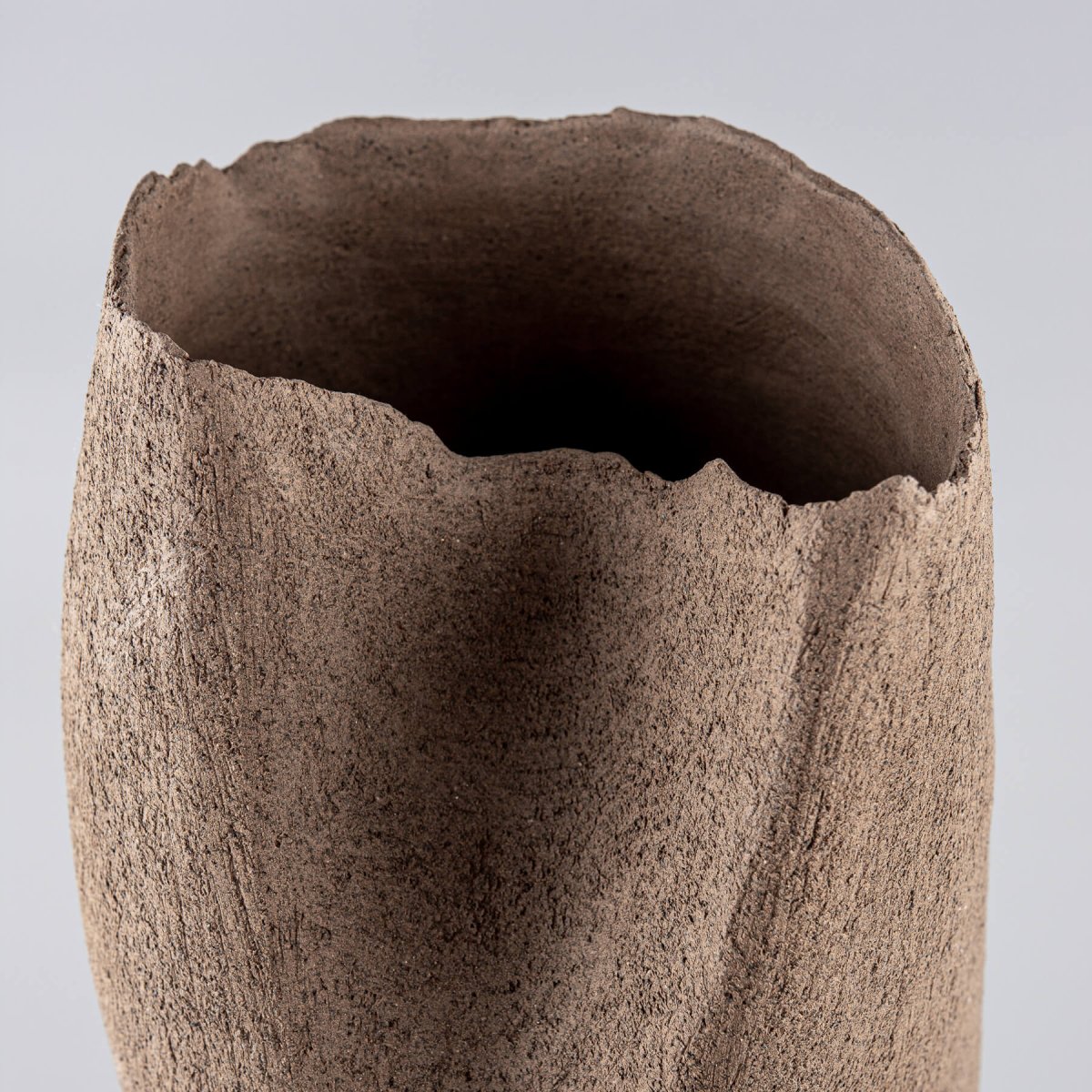Close-up of a handcrafted stoneware vase highlighting natural clay texture for home decor.