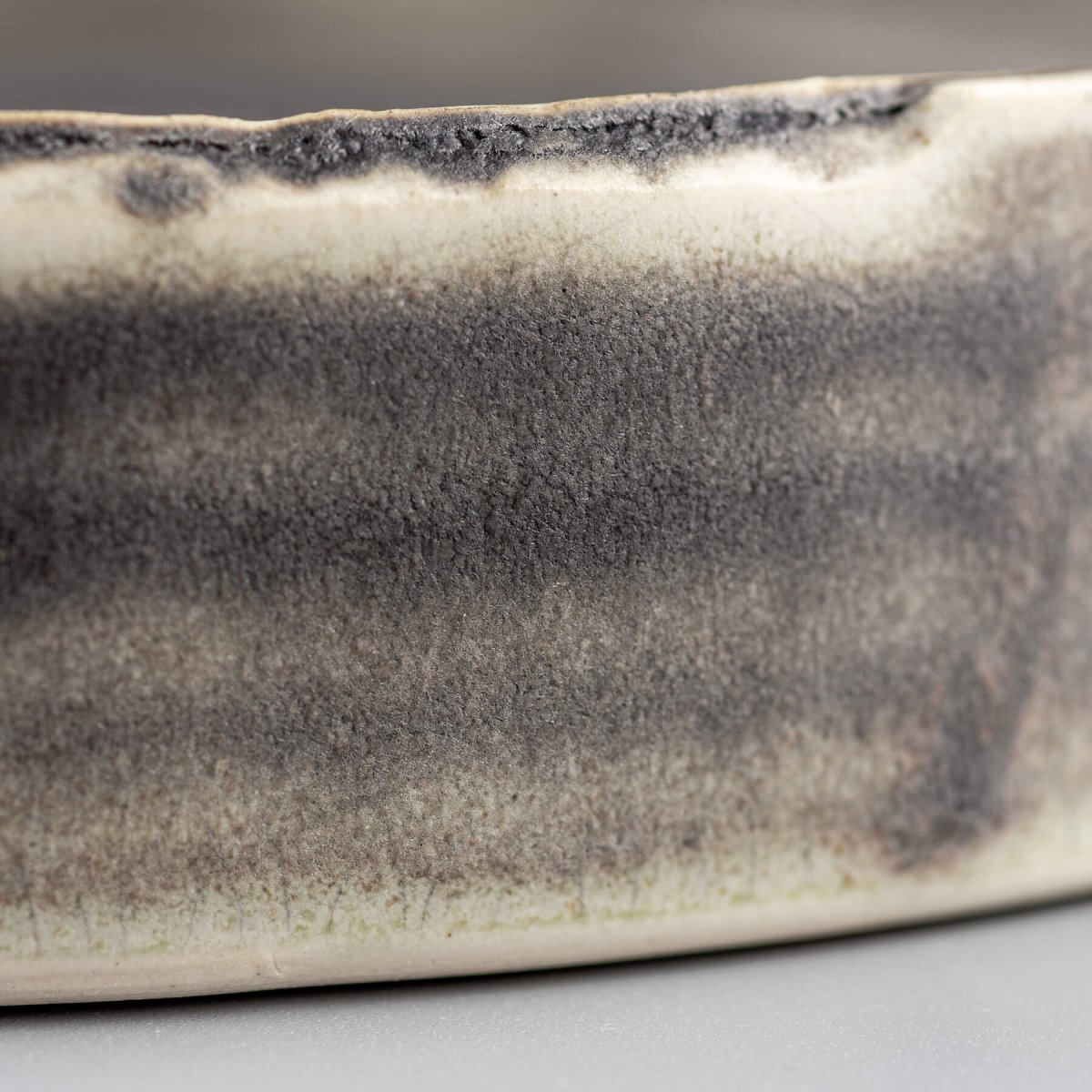 Close-up of a luxury ceramic plate showcasing smooth dark olive-green glaze for refined culinary presentation.