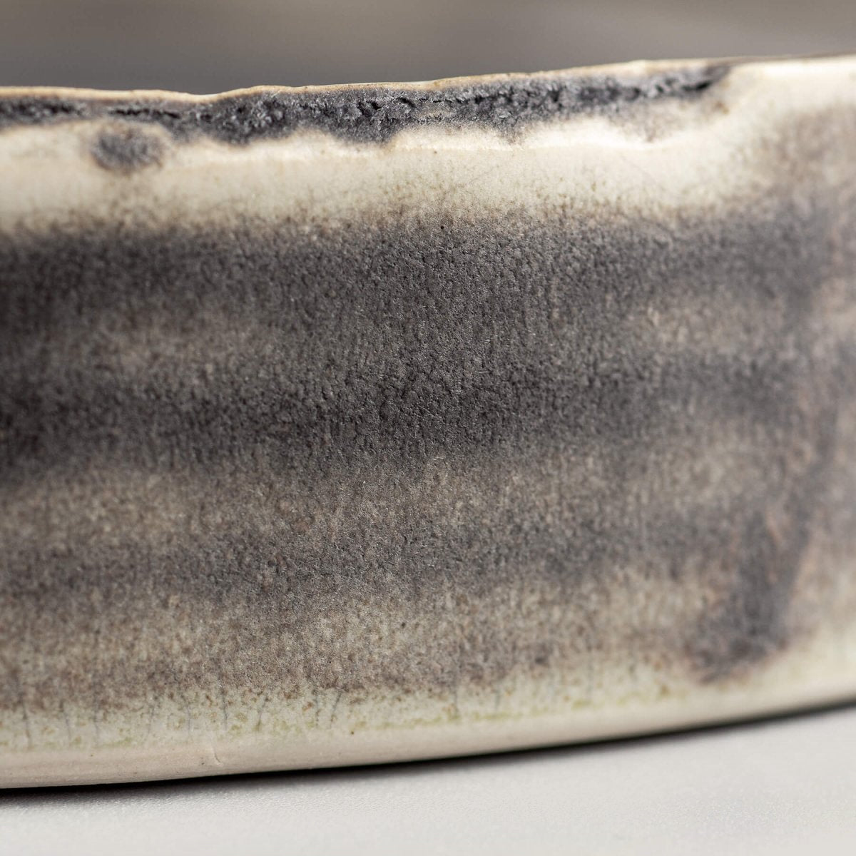 Close-up of a luxury ceramic plate showcasing smooth dark olive-green glaze for refined culinary presentation.