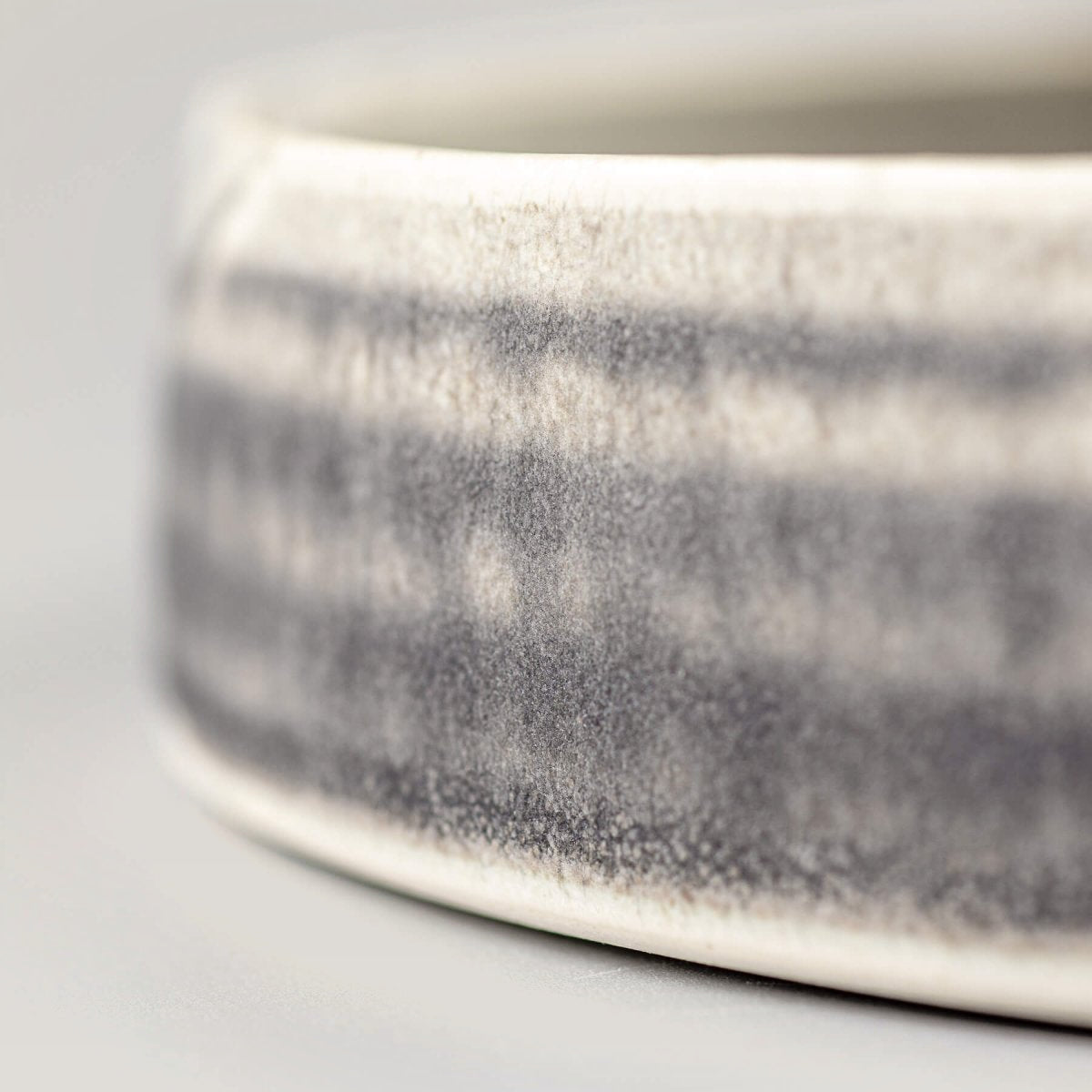 Close-up of plate’s side showing refined stoneware texture and artisan glaze finish.