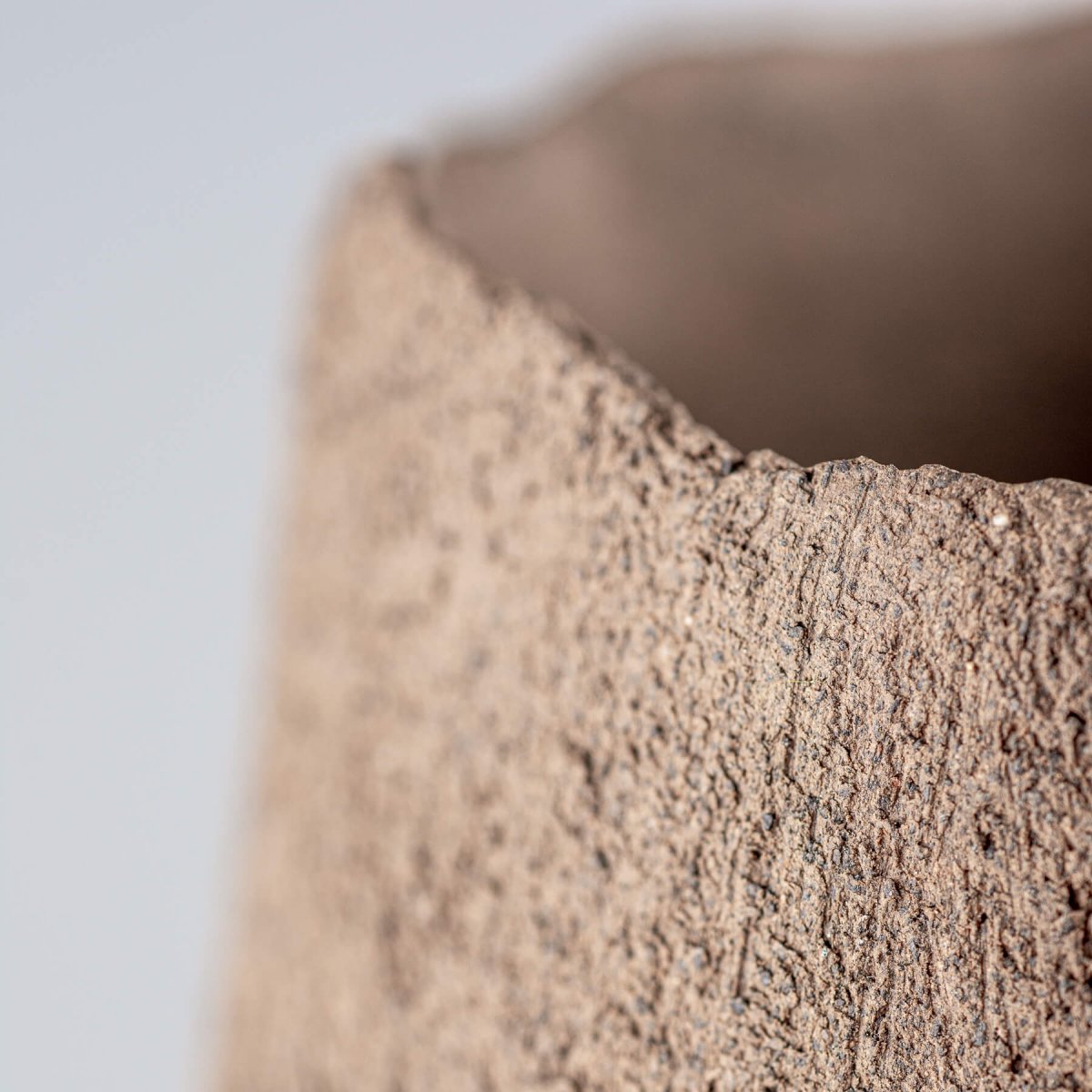 Unglazed modern stoneware vase as a luxury centerpiece for boutique hotel interiors.