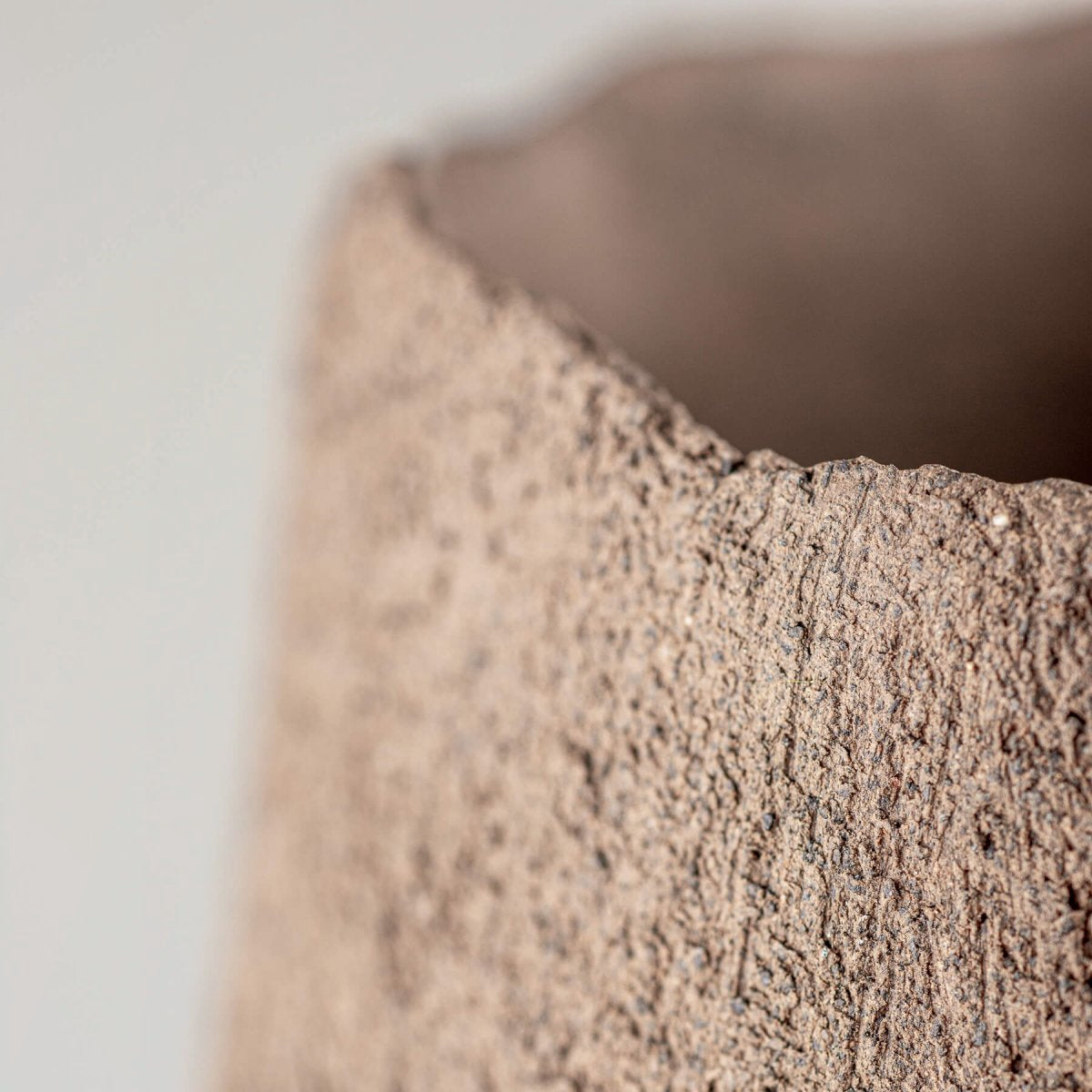 Unglazed modern stoneware vase as a luxury centerpiece for boutique hotel interiors.