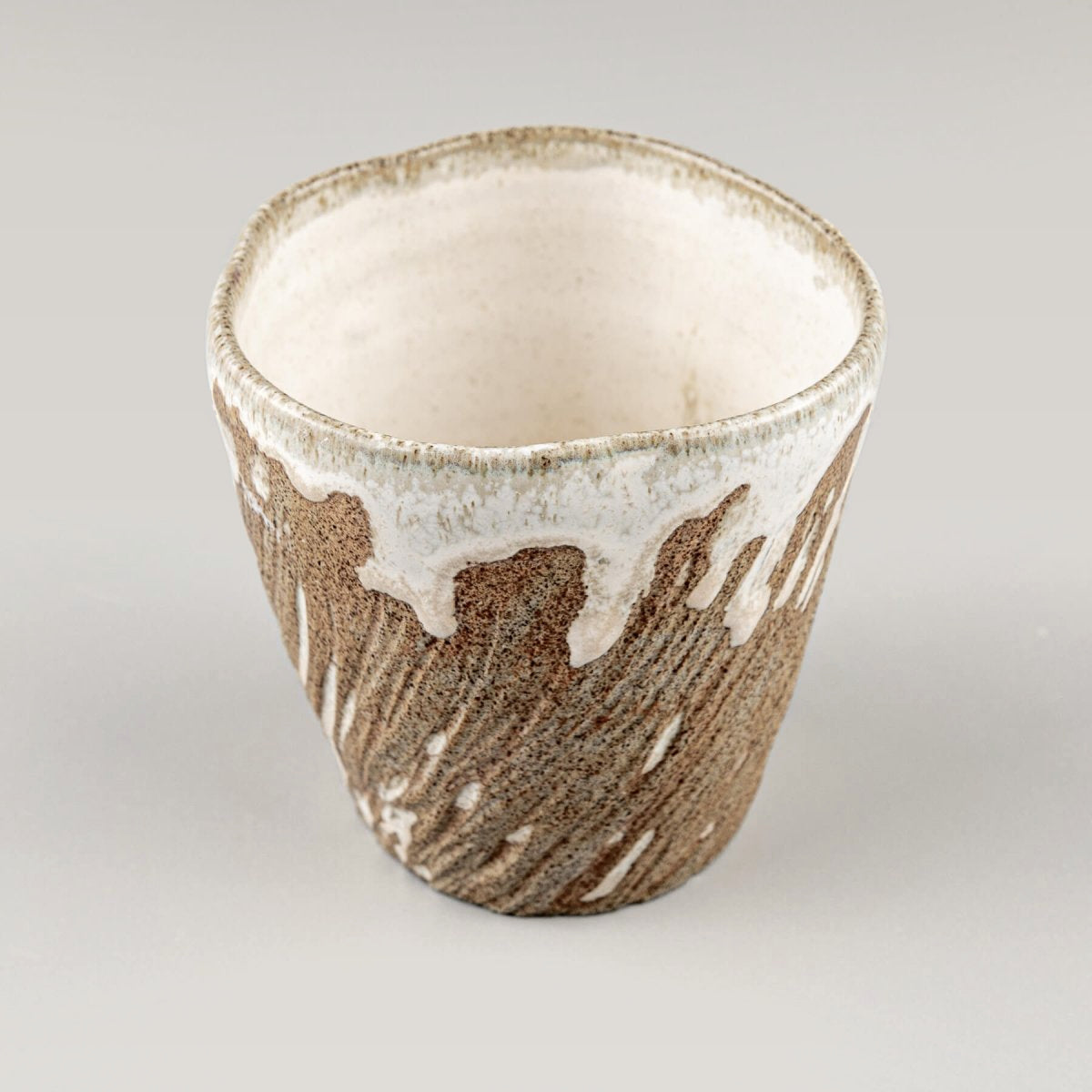 Handmade ceramic espresso mug with earthy stoneware body and semi-gloss white glaze accent.
