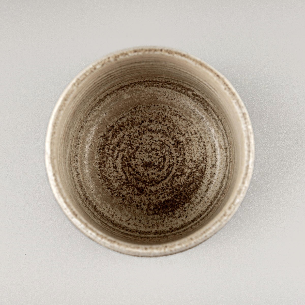 Top view of pottery coffee mug showing smooth matte glazed interior in natural stoneware tones.